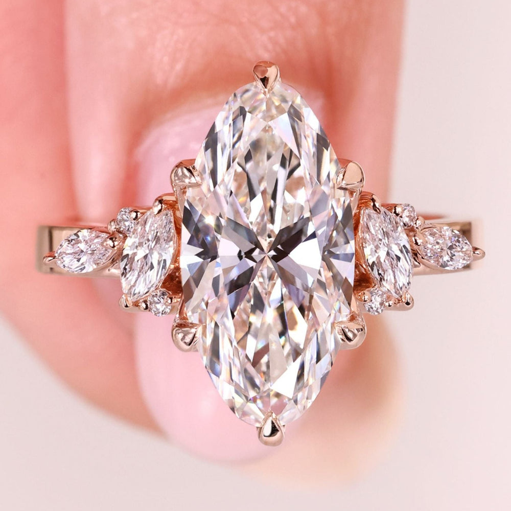 Moval diamond ring with marquise and round side stones.
