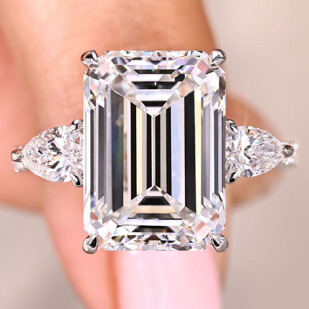 Emerald cut diamond engagement ring with pear side stones.
