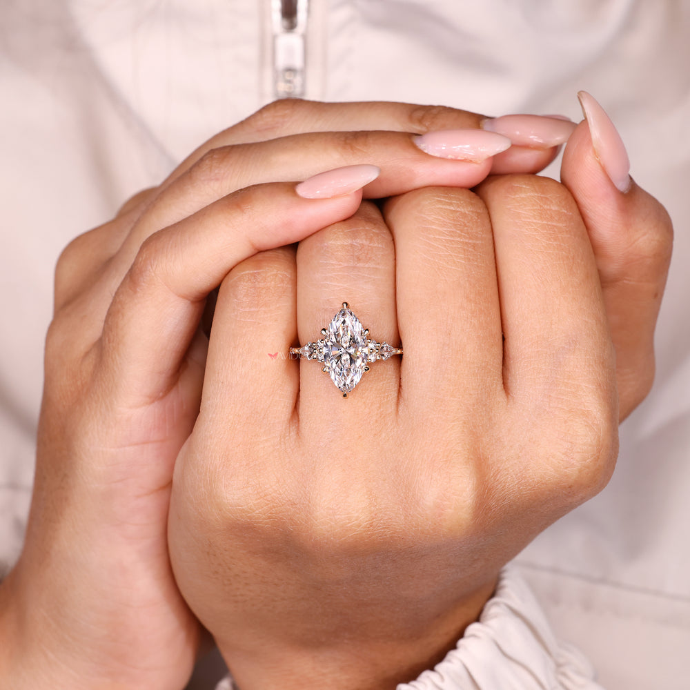 Marquise diamond ring with tapered shank and pave details.
