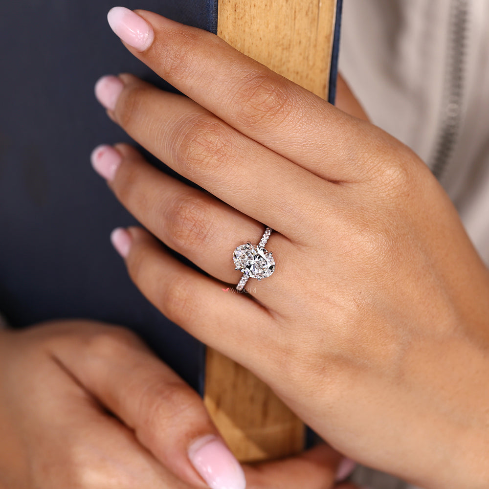 Oval diamond ring with round hidden halo accents.