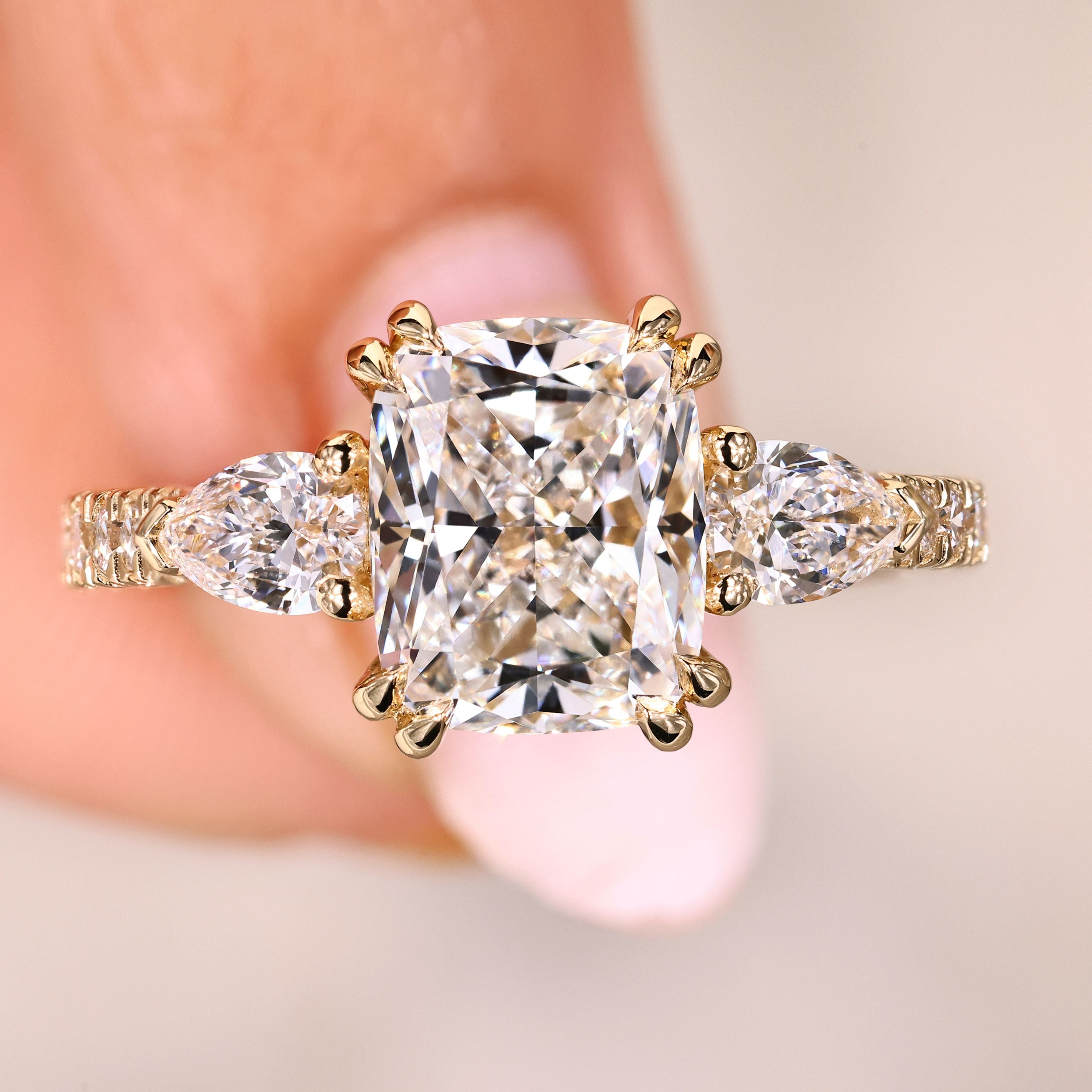 Cushion cut diamond ring with pear side stones.
