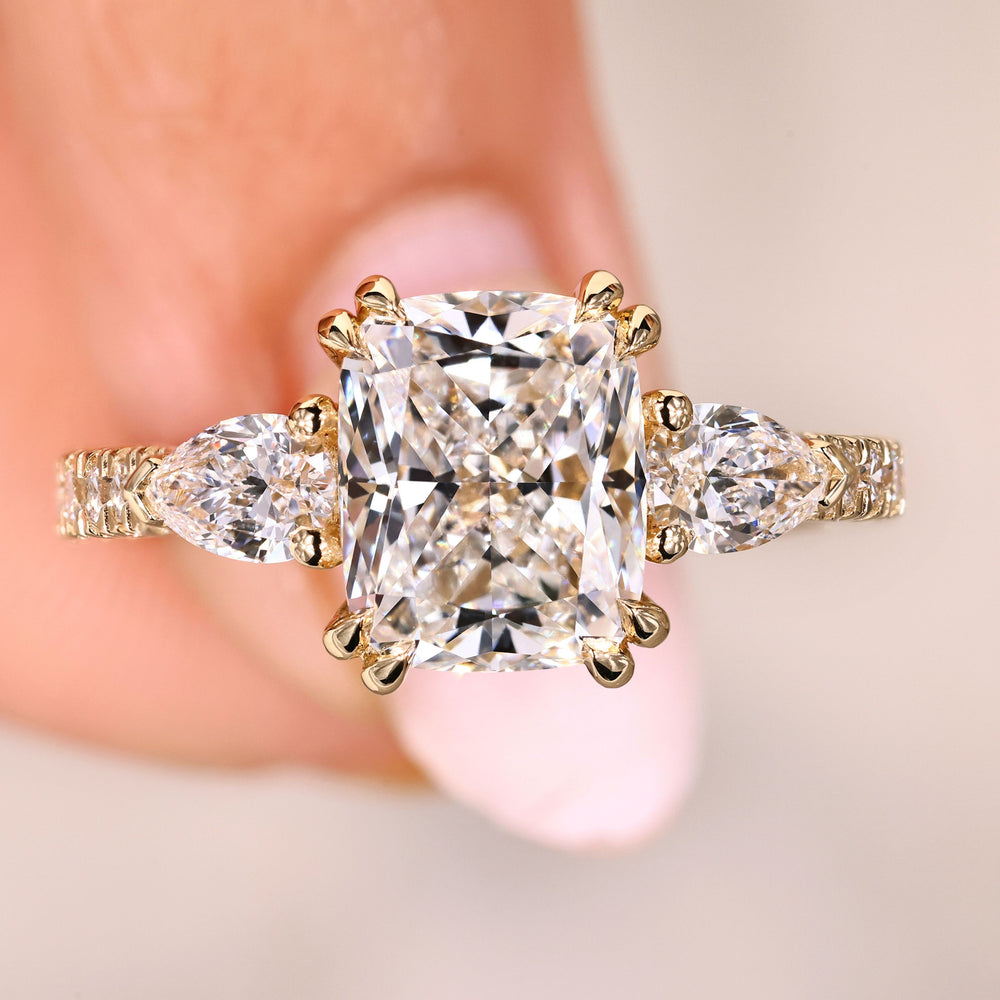 Cushion cut diamond ring with pear side stones.
