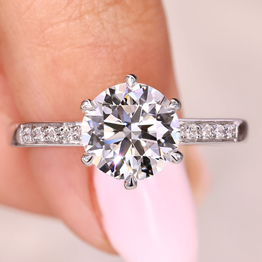 Round cut diamond ring with pave style and claw prongs
