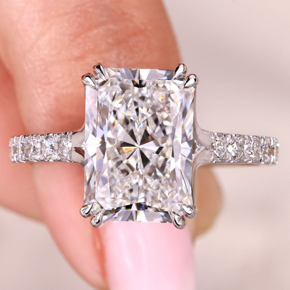 Radiant cut diamond ring with pave setting band.
