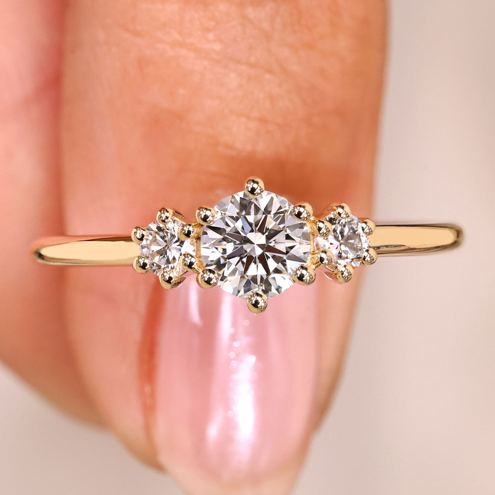 Round cut diamond ring three stone prong setting.
