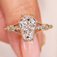 Elongated shield cut diamond ring with round side stones.
