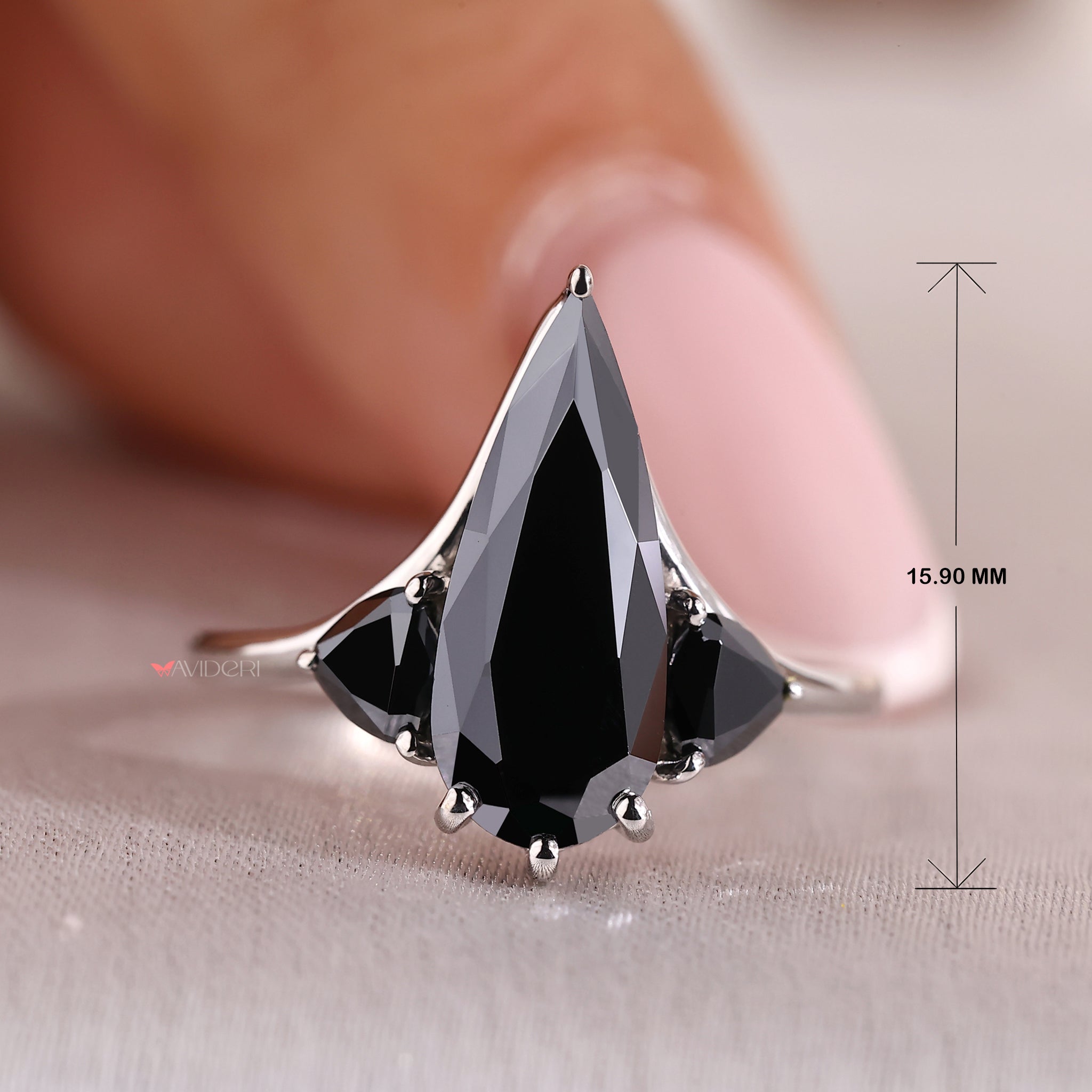 Three stone engagement ring with a pear-cut center and trillions.