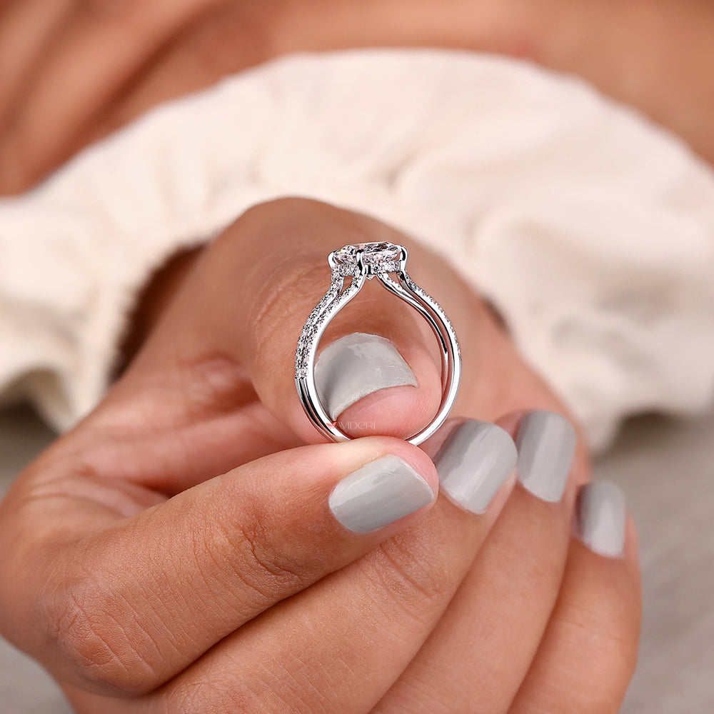 Hidden halo oval cut diamond ring with four claw prongs.
