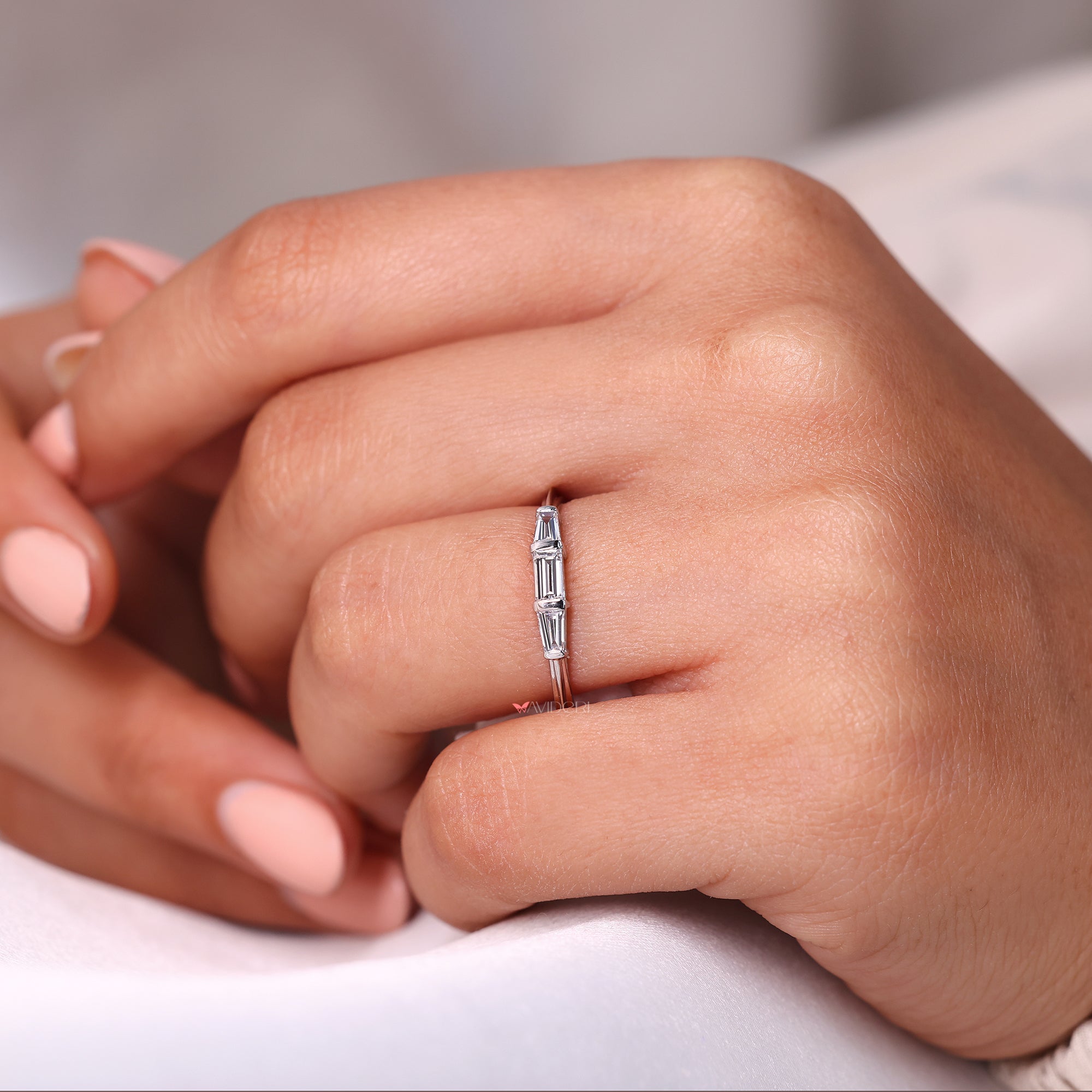 Tapered baguette side stone in 3 stone wedding band.