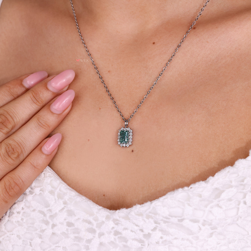 Cyan blue moissanite pendant with radiant cut center.
