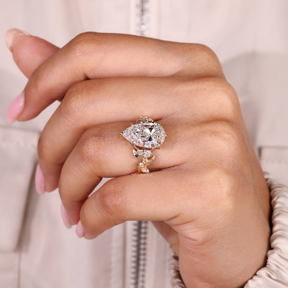 Pear cut diamond ring with round side stone accents.
