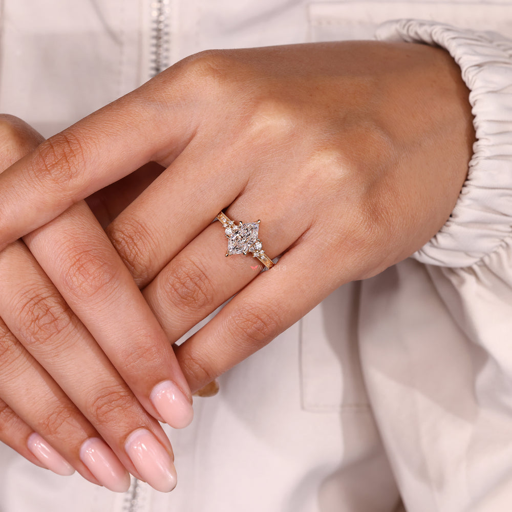 Round side stone marquise diamond ring design.
