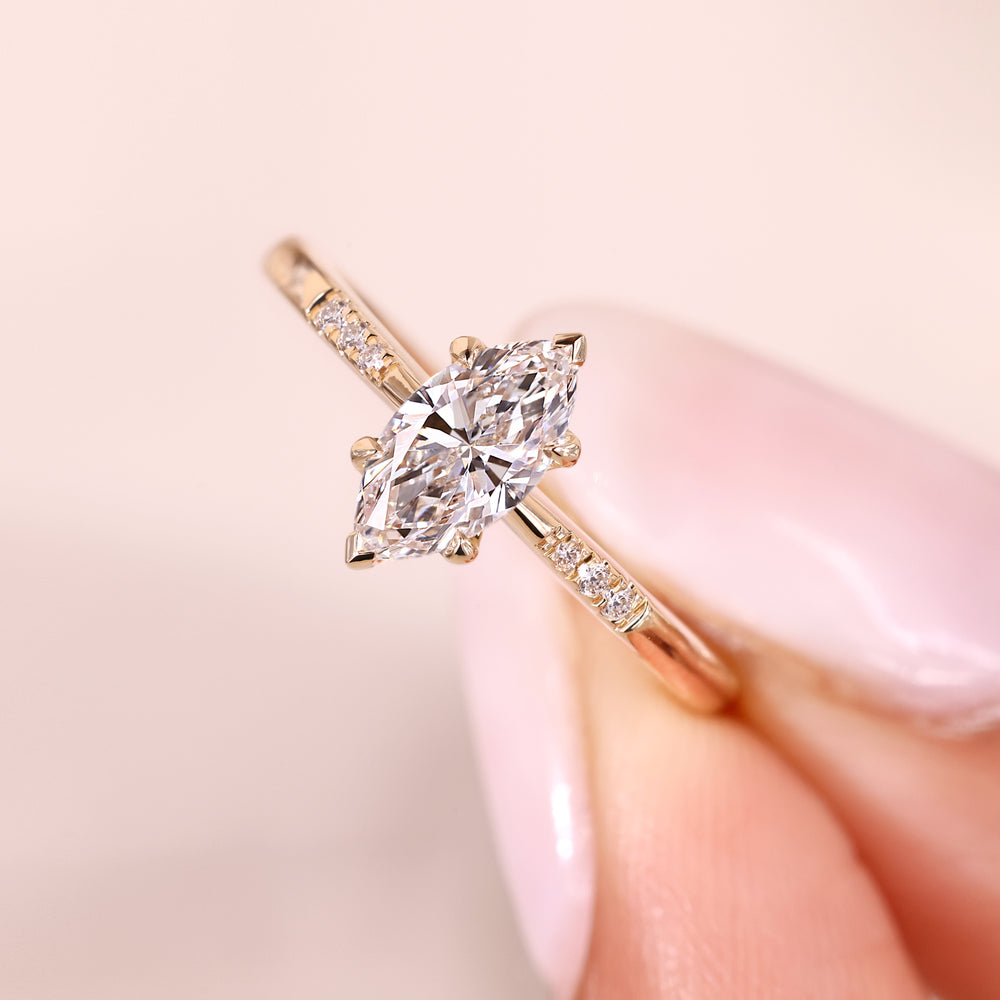 Marquise diamond engagement ring with pave style band.
