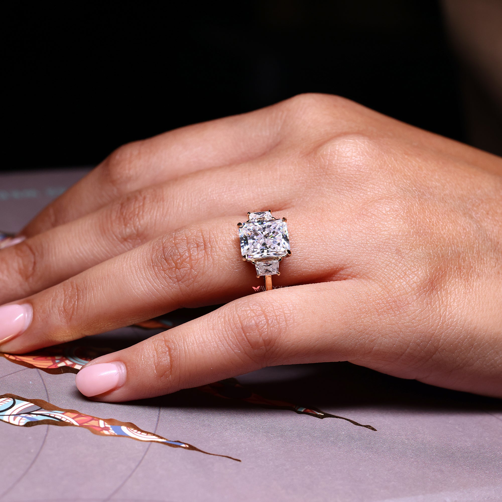 Radiant cut center moissanite ring with trapezoid side stones.
