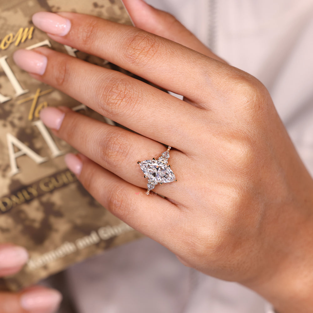 Marquise engagement ring with round pave and tapered shank.
