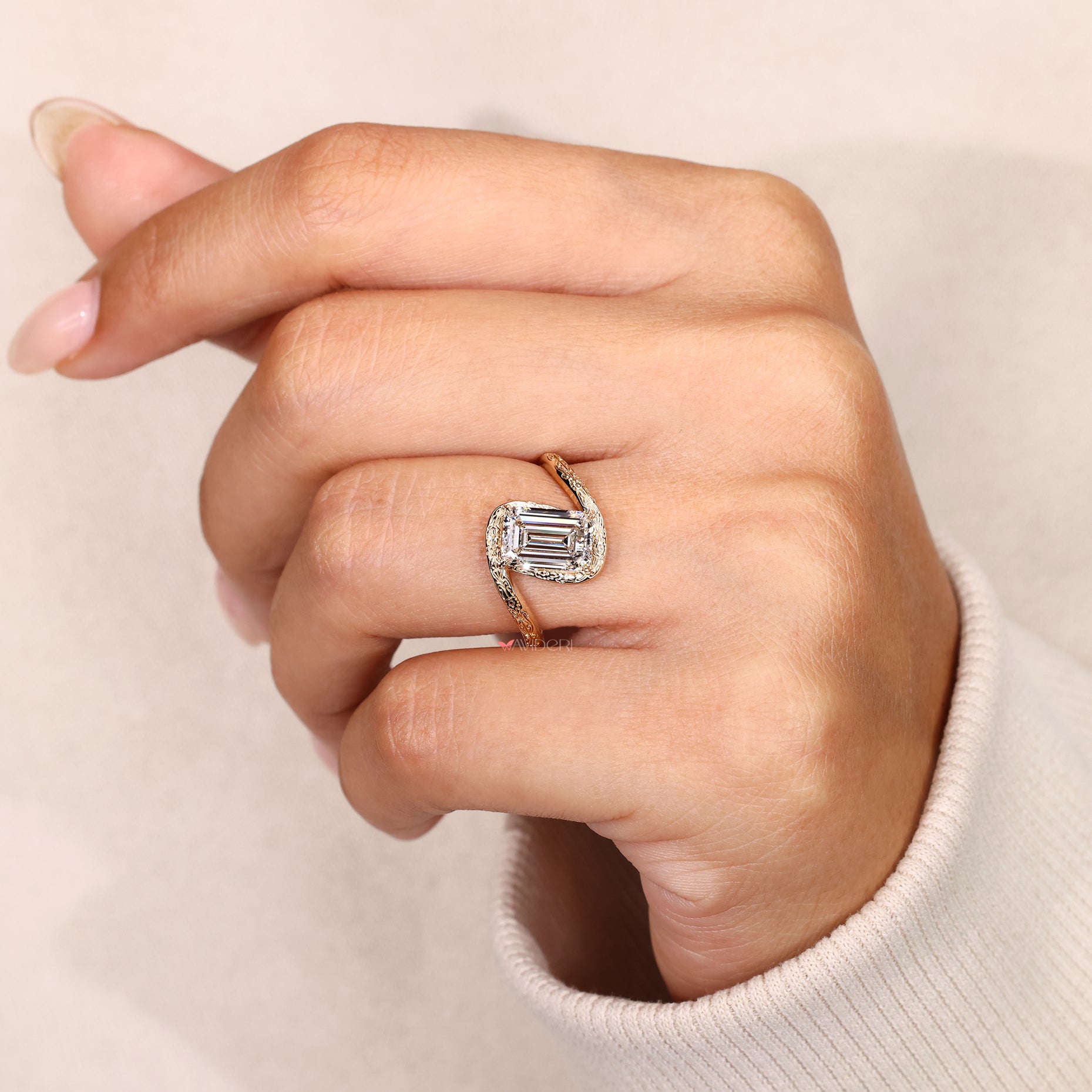 Bypass emerald diamond ring with engraved details.
