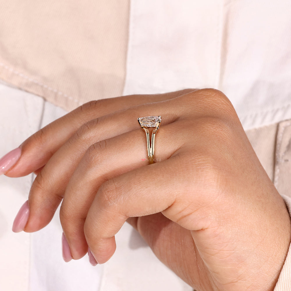 Split ring shank pear engagement ring with a hidden halo setting, creating a unique and dazzling design.
