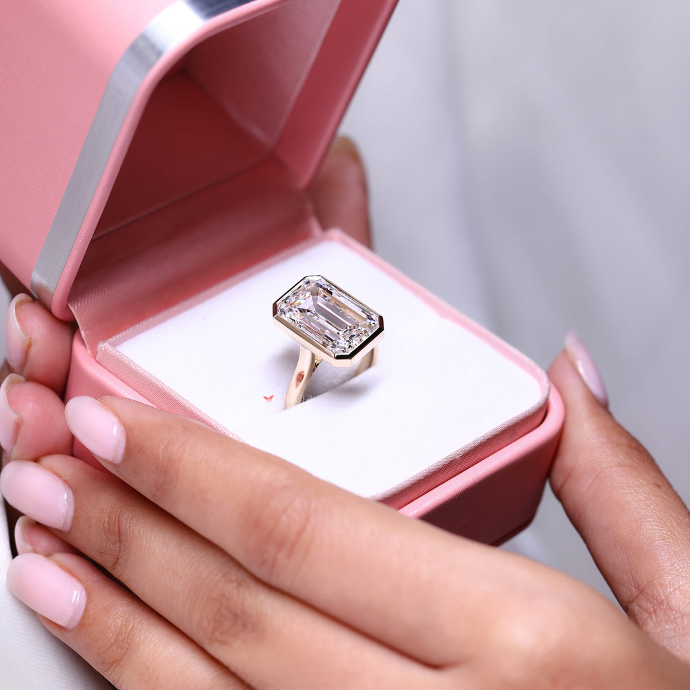 Solitaire Diamond Ring with Emerald Cut and Bezel Setting.