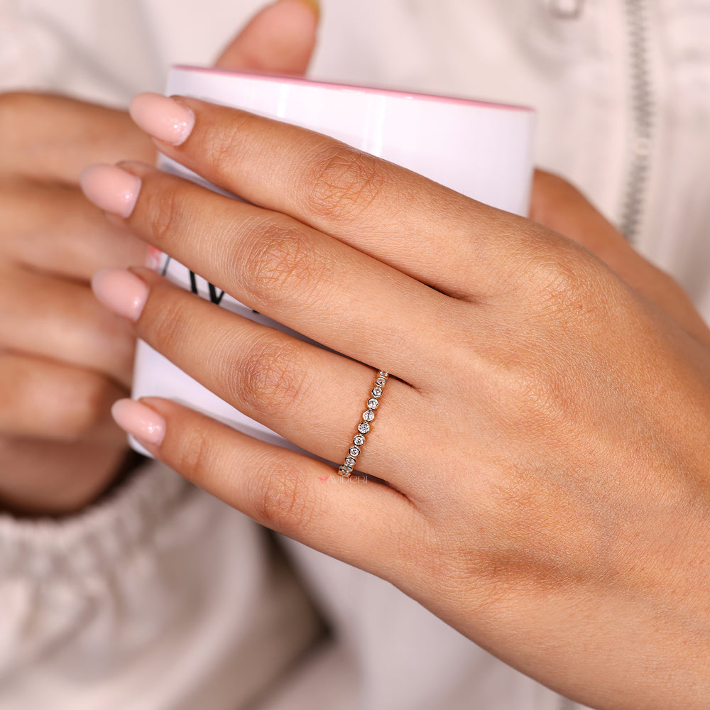 Eternity wedding band with round bezel diamonds.
