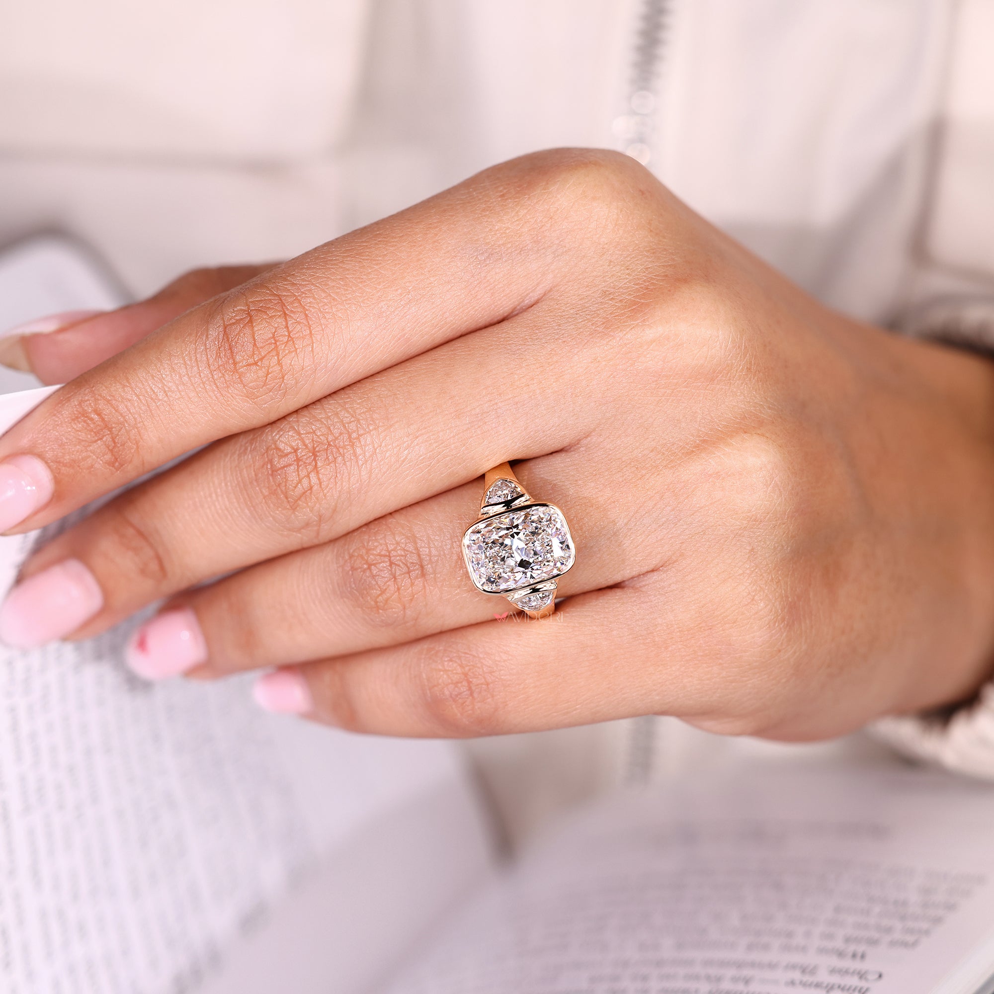 Cushion cut ring with trillion side stones and bezel setting.