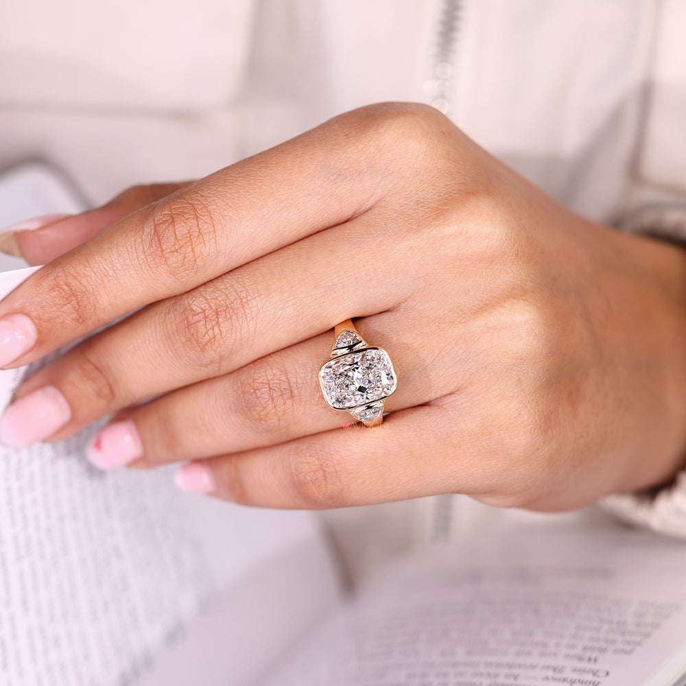 Cushion cut ring with trillion side stones and bezel setting.