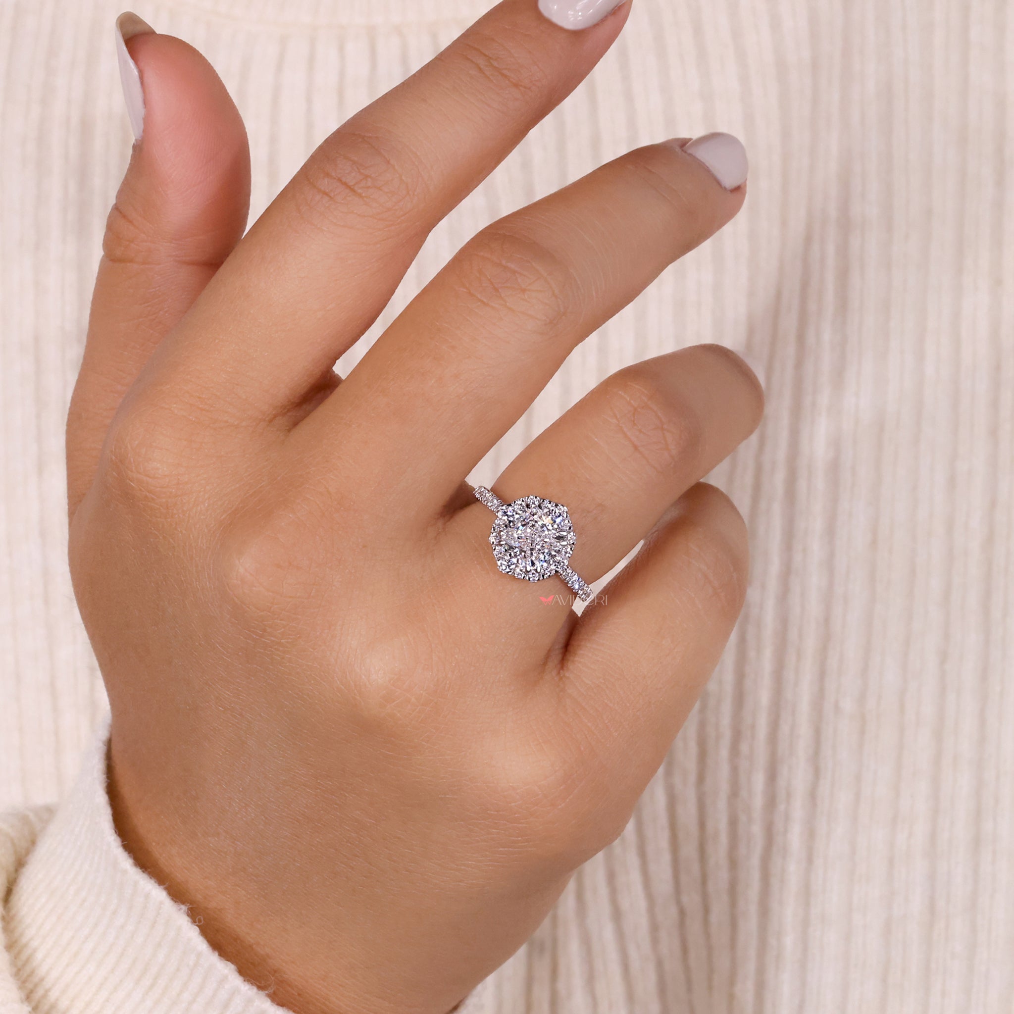 Cushion cut diamond with halo and pave stones, offering a brilliant design for engagements and special occasions.
