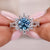 round blue diamond engagement ring with prong setting in white gold.
