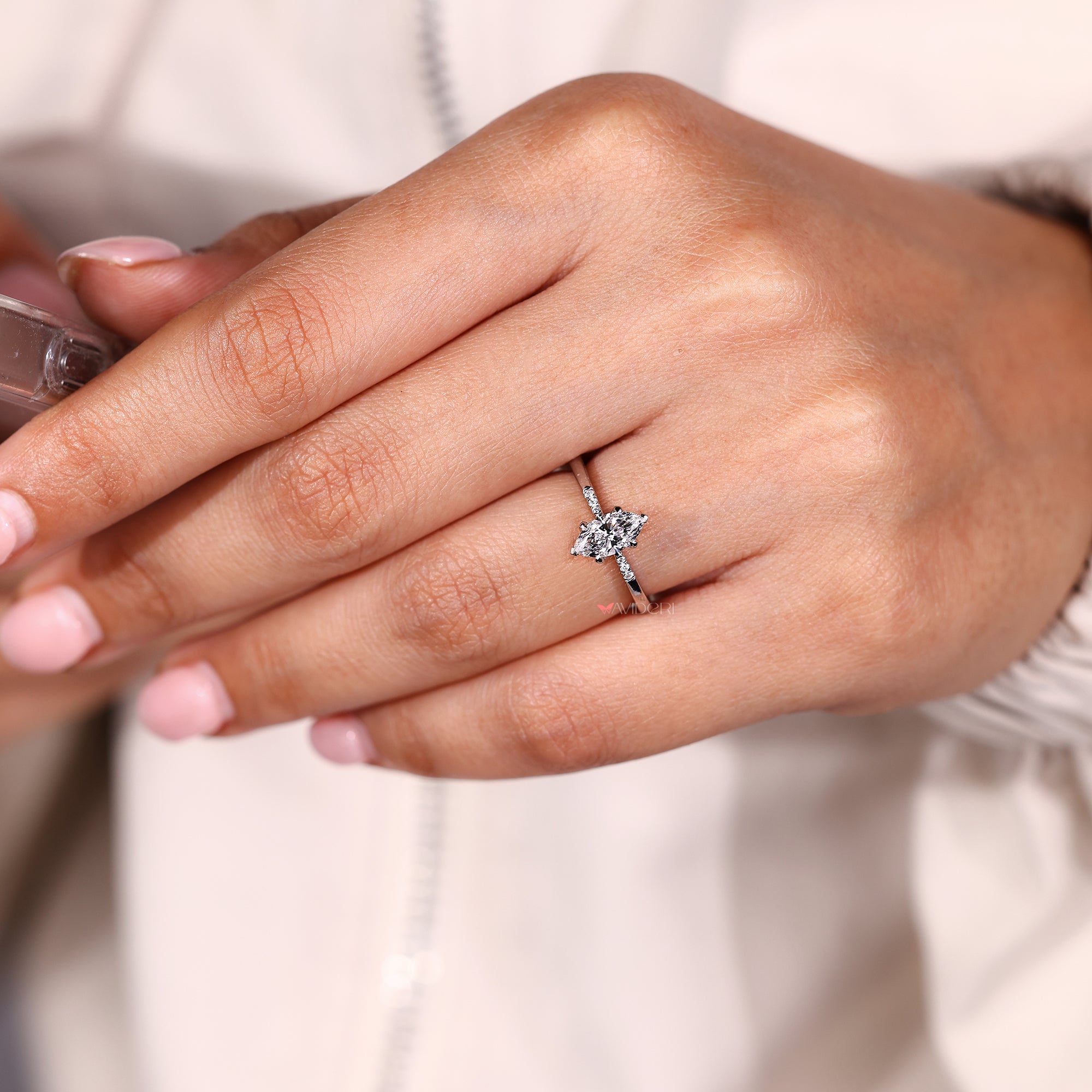 Side stone ring featuring marquise diamond and tapered shank.