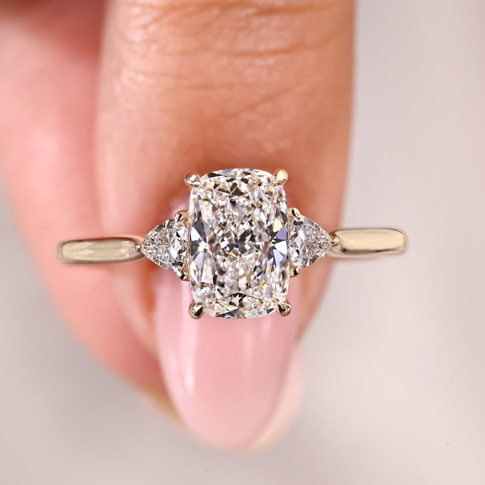 Long cushion cut diamond ring with cathedral setting.