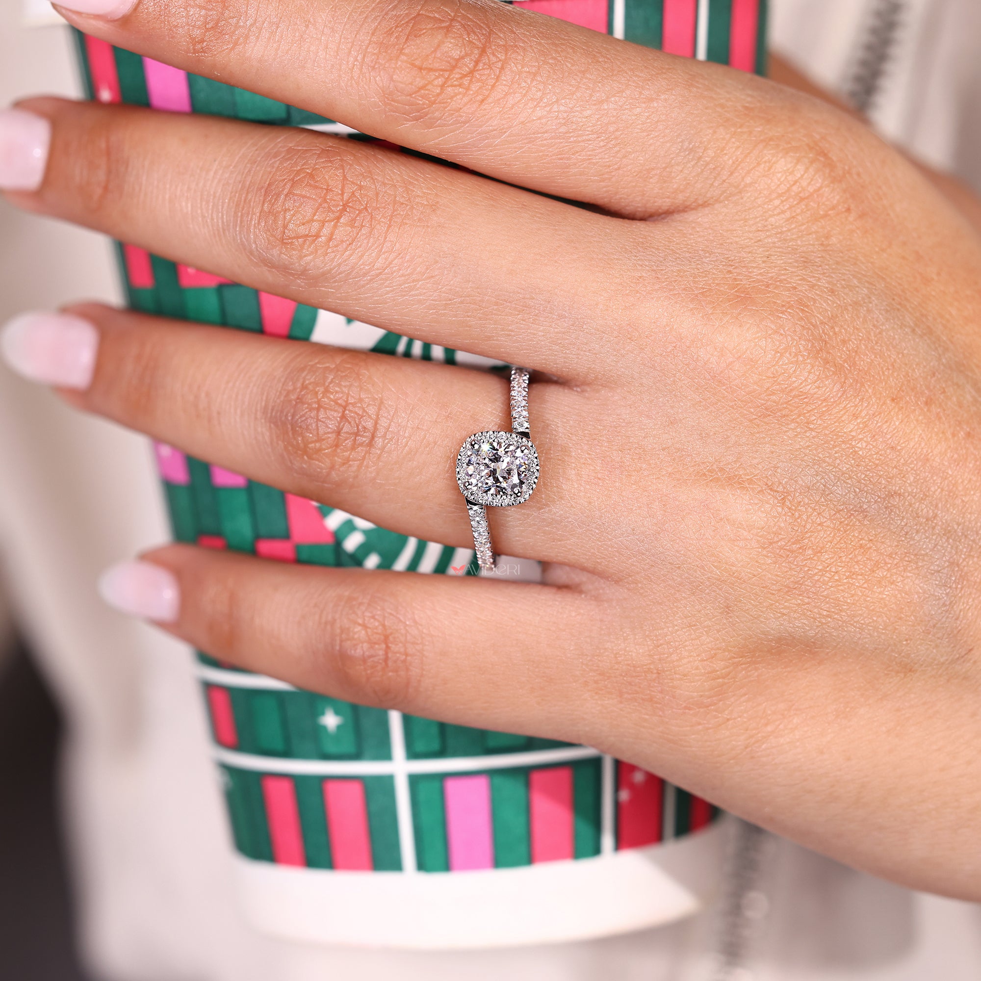 Cushion diamond ring with round halo and bypass band.
