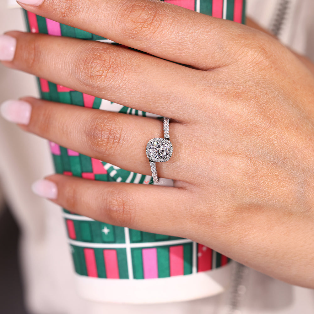 Cushion diamond ring with round halo and bypass band.
