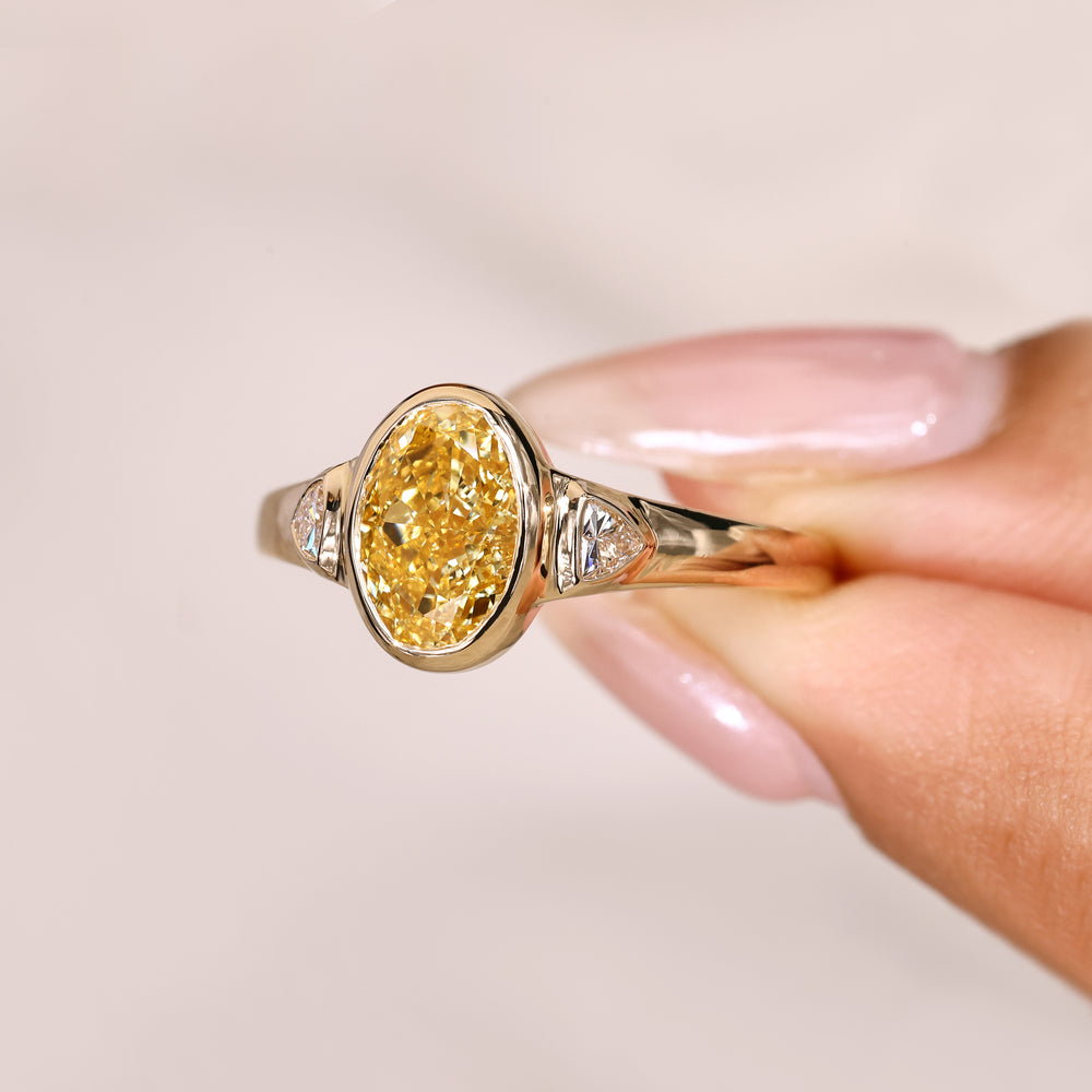 Oval ring with cathedral setting and side stones.
