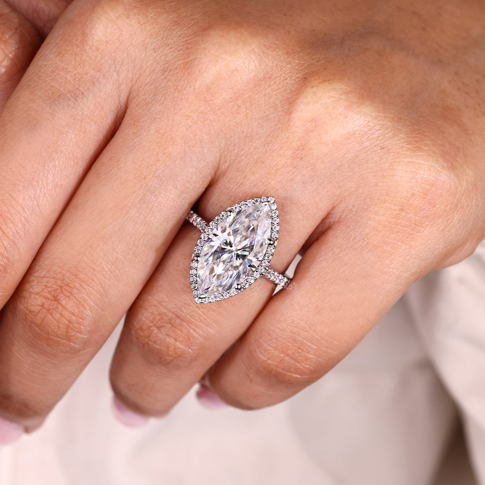 Halo style marquise ring with round moissanite accents.