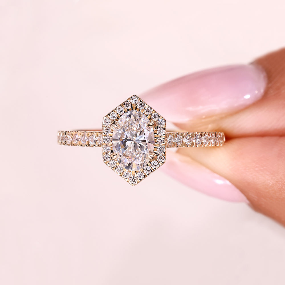 Oval ring with round diamond halo design.
