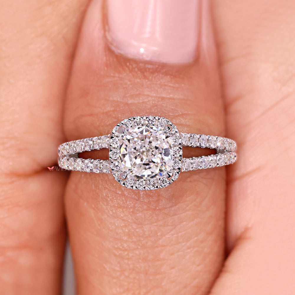 Cushion cut diamond ring with halo and pave band.
