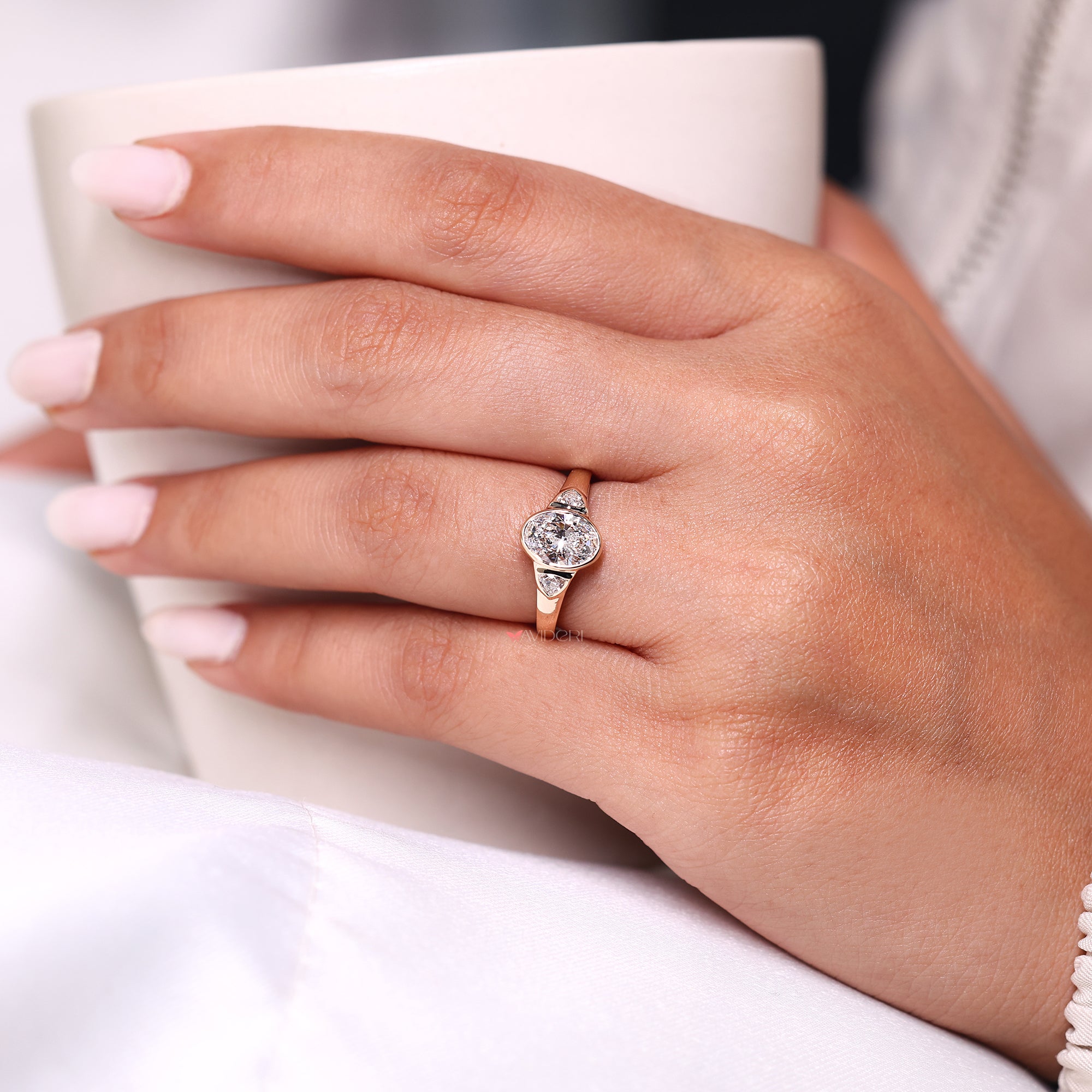 Oval diamond ring with two trillion side diamonds.