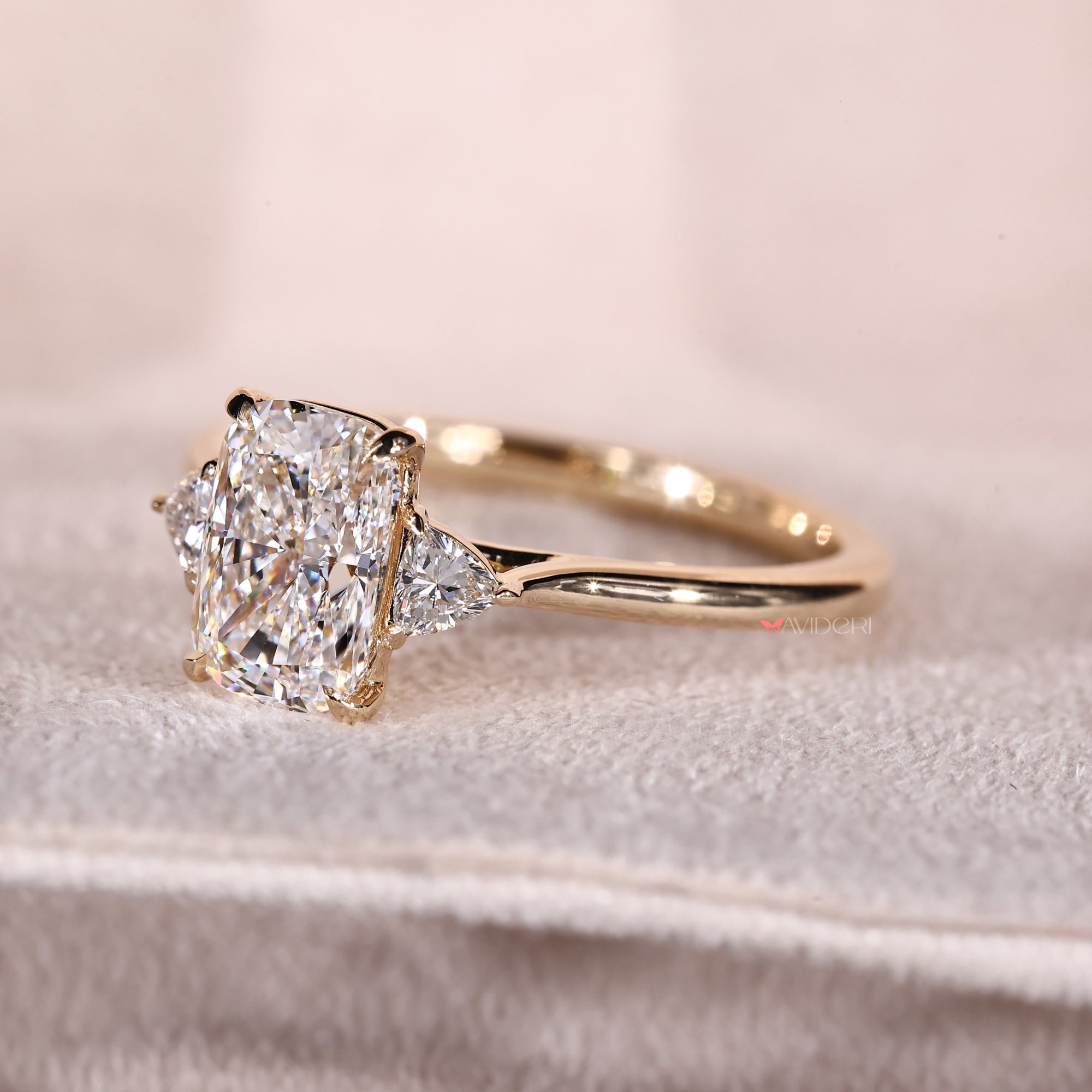 Trillion side stone engagement ring in yellow gold.