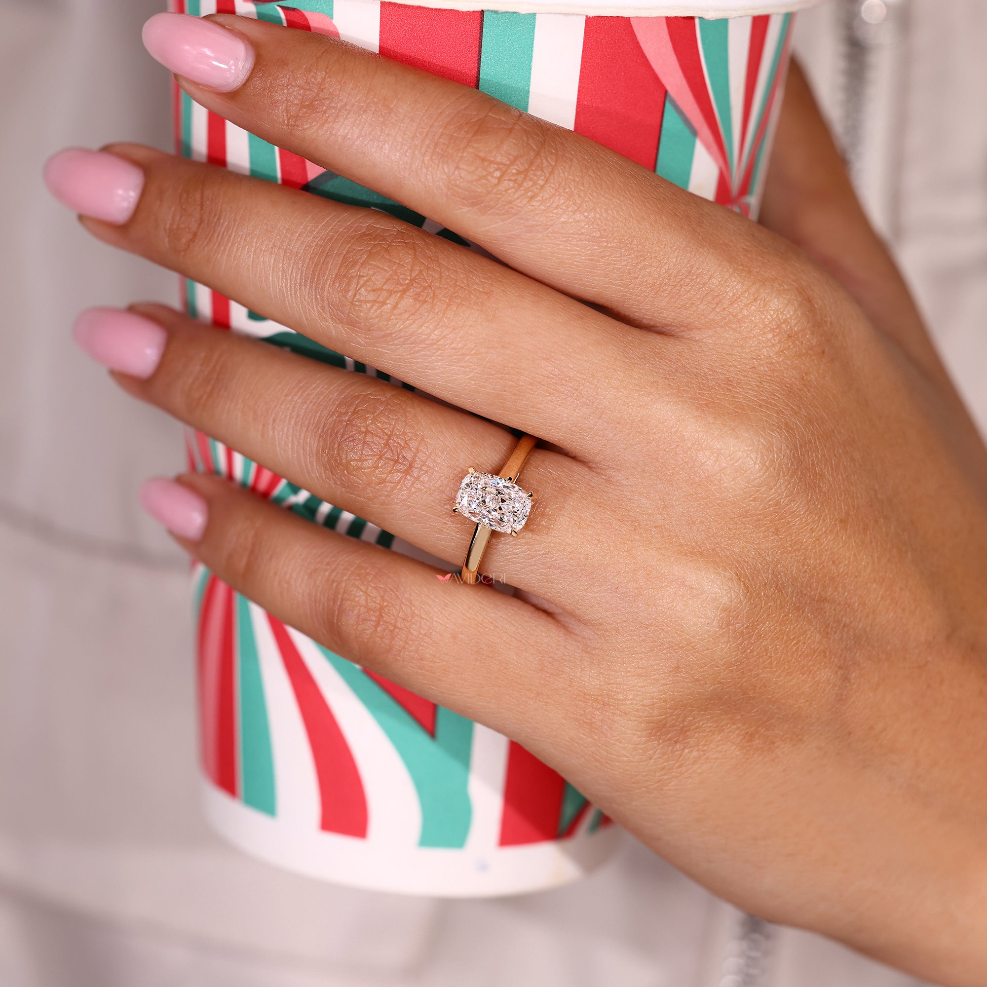 Solitaire cushion cut diamond ring with four claw prongs. 
