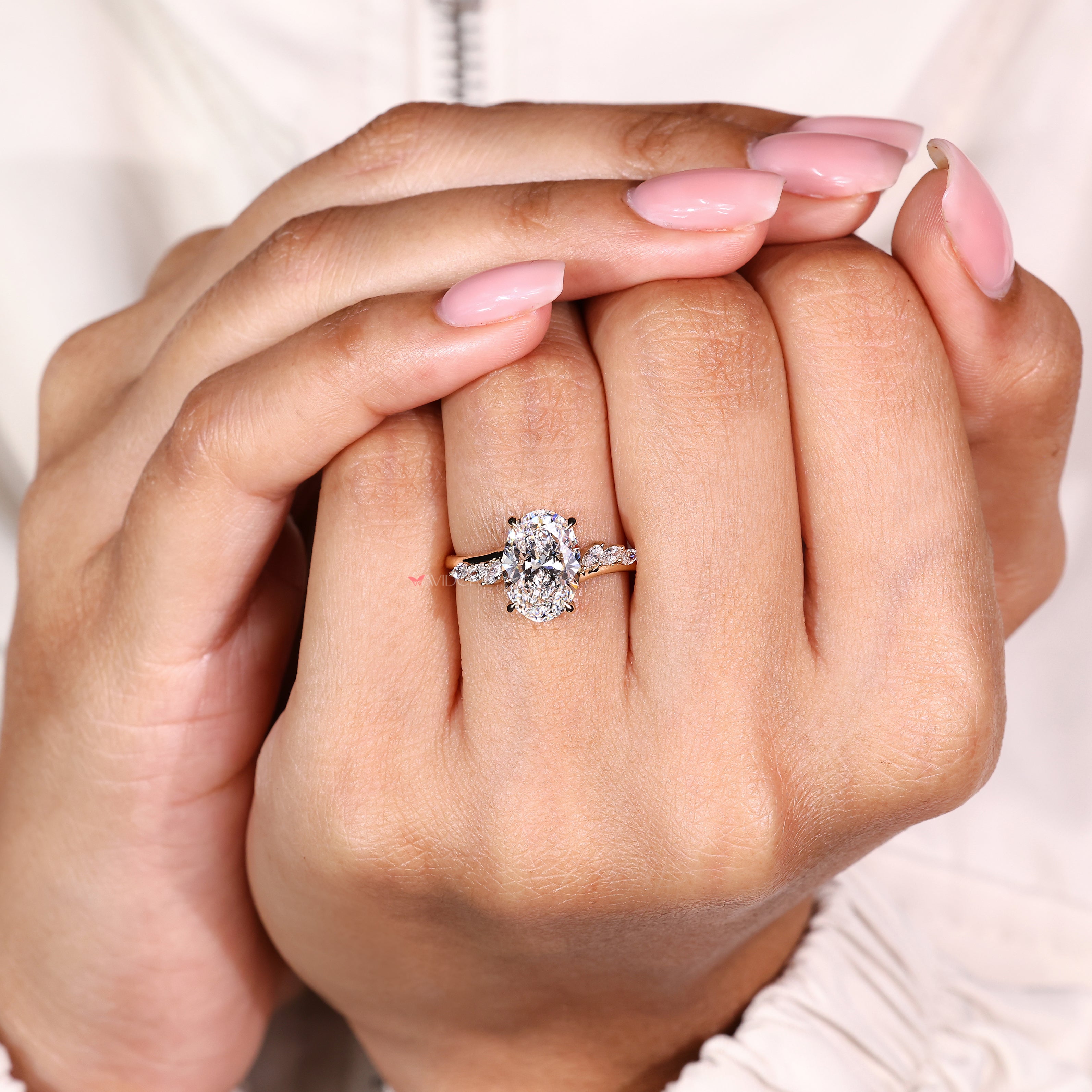 Oval diamond ring with four claw prongs and accents
