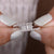 A baguette engagement ring placed on a white display.
