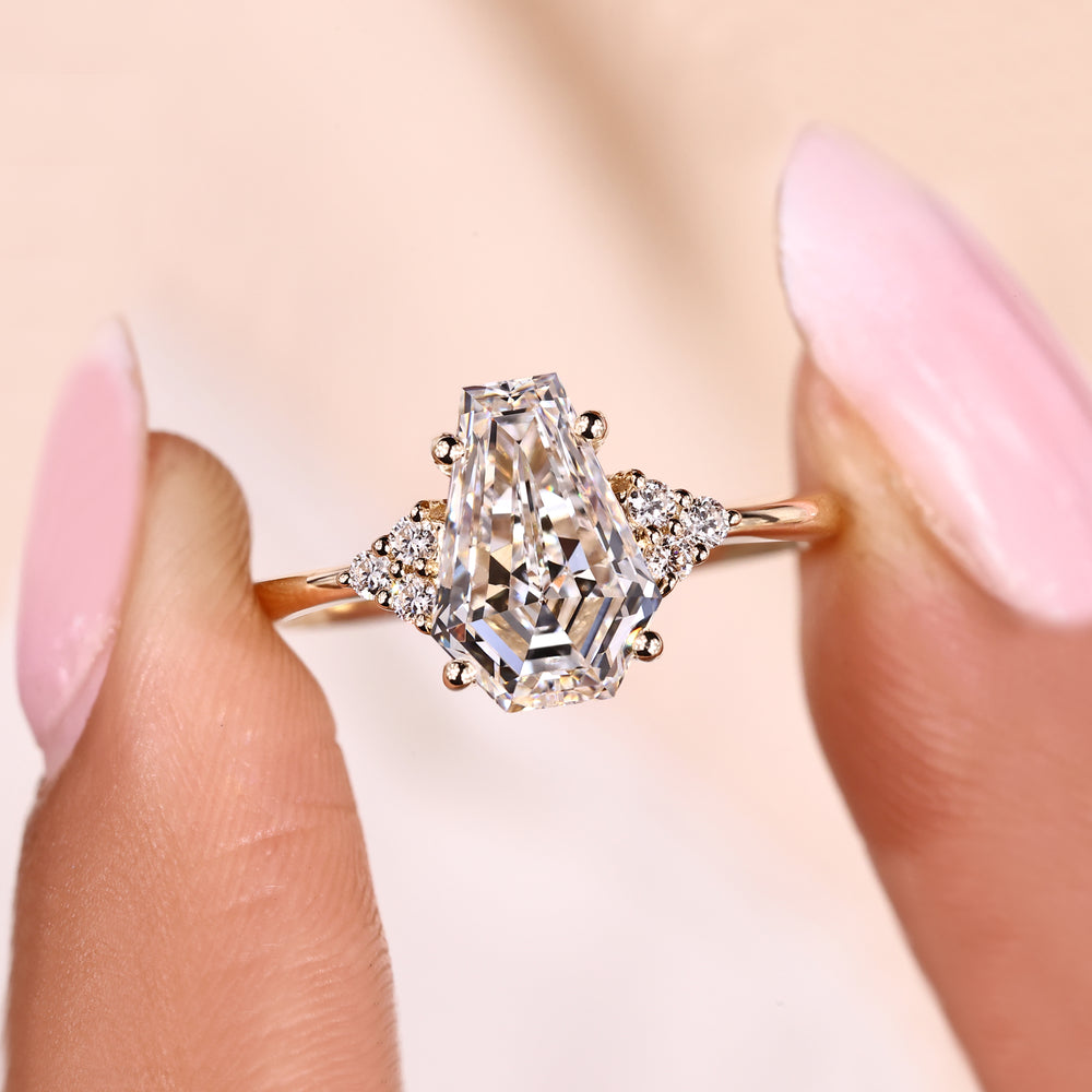 Seven stone ring with coffin cut center and round sides.