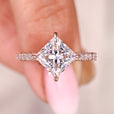 Princess cut engagement ring with compass prong setting and pave band.