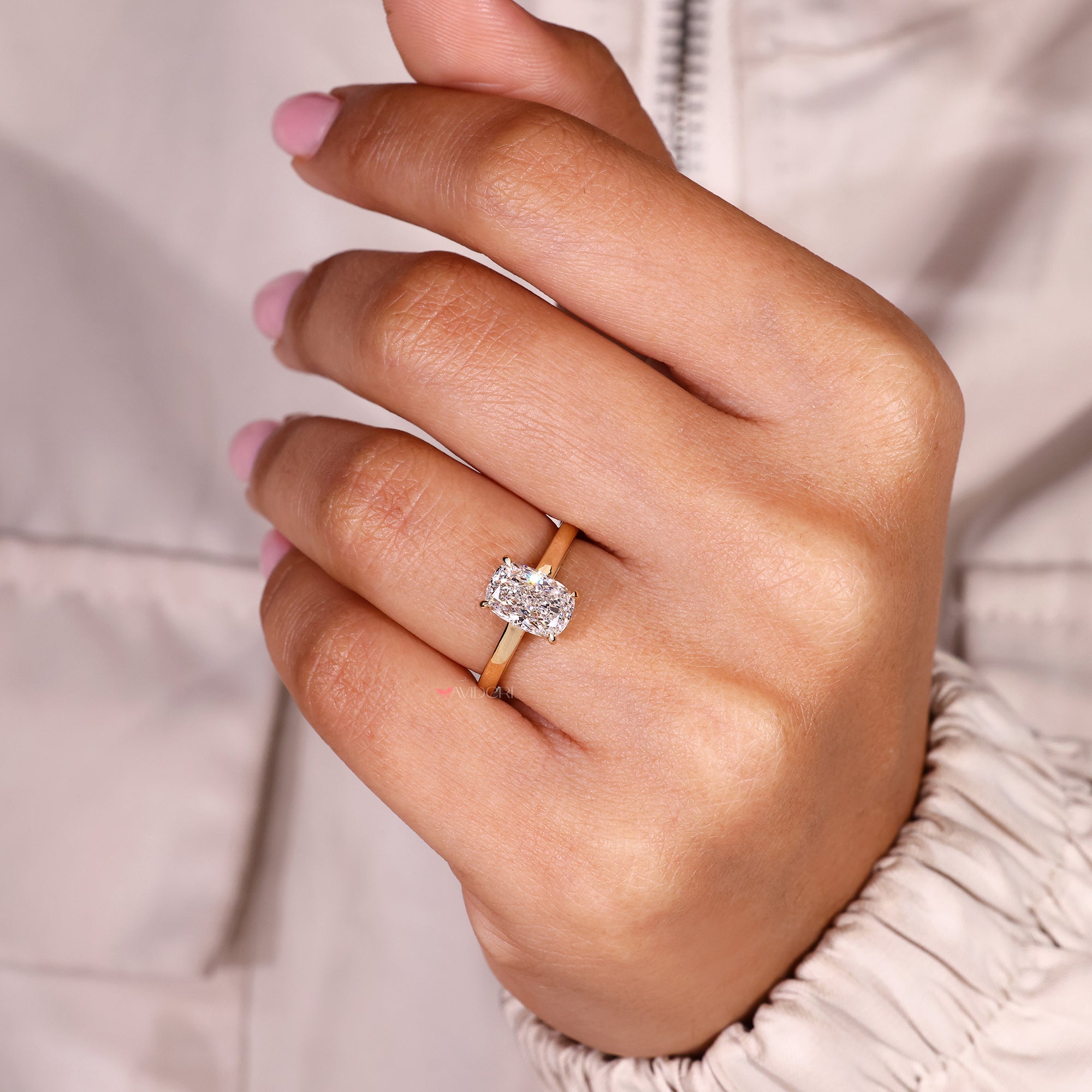 Cushion cut diamond ring with classic four claw prongs.