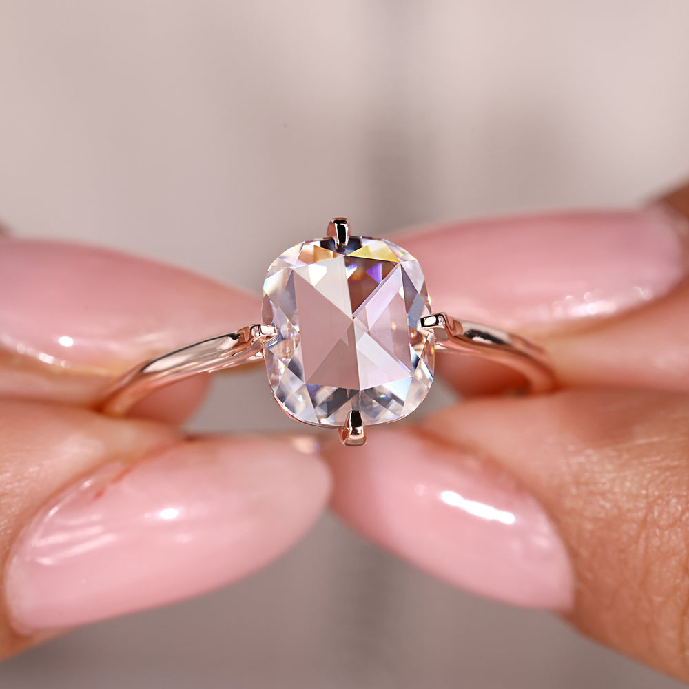 Solitaire ring featuring a cushion rose cut moissanite in a rose gold setting.
