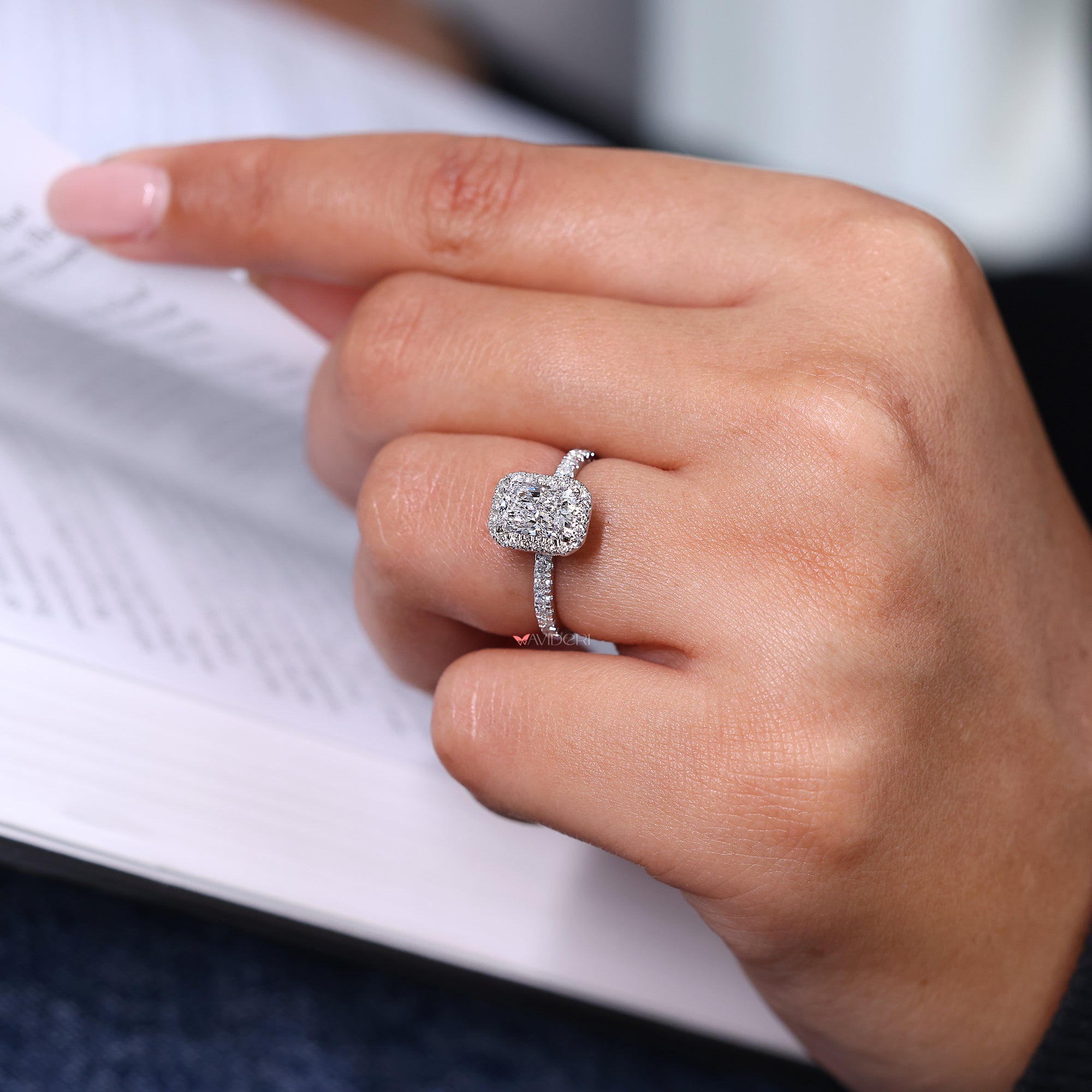 Halo diamond ring with radiant cut center and pave band.