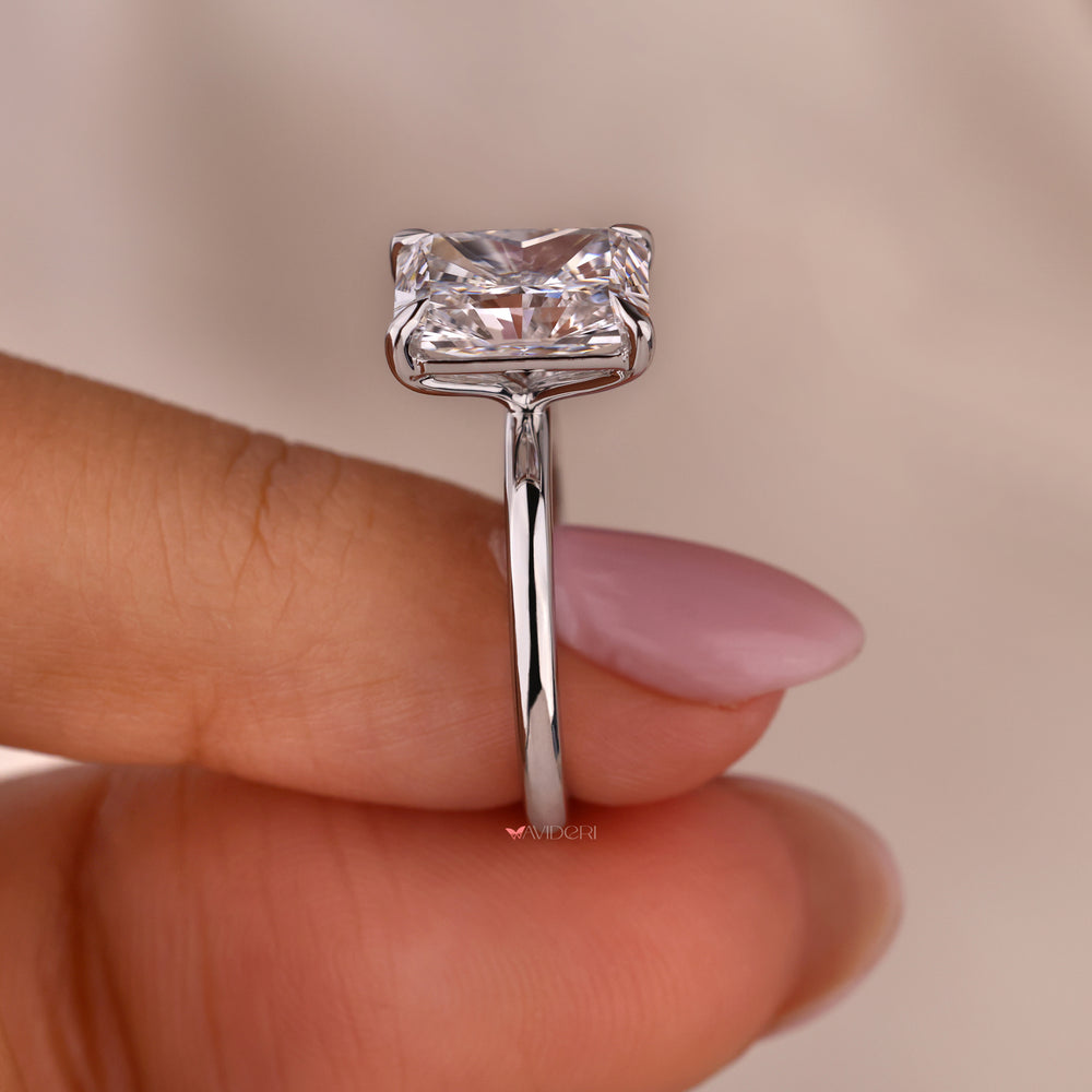 Elegant solitaire engagement ring with a radiant diamond centerpiece.
