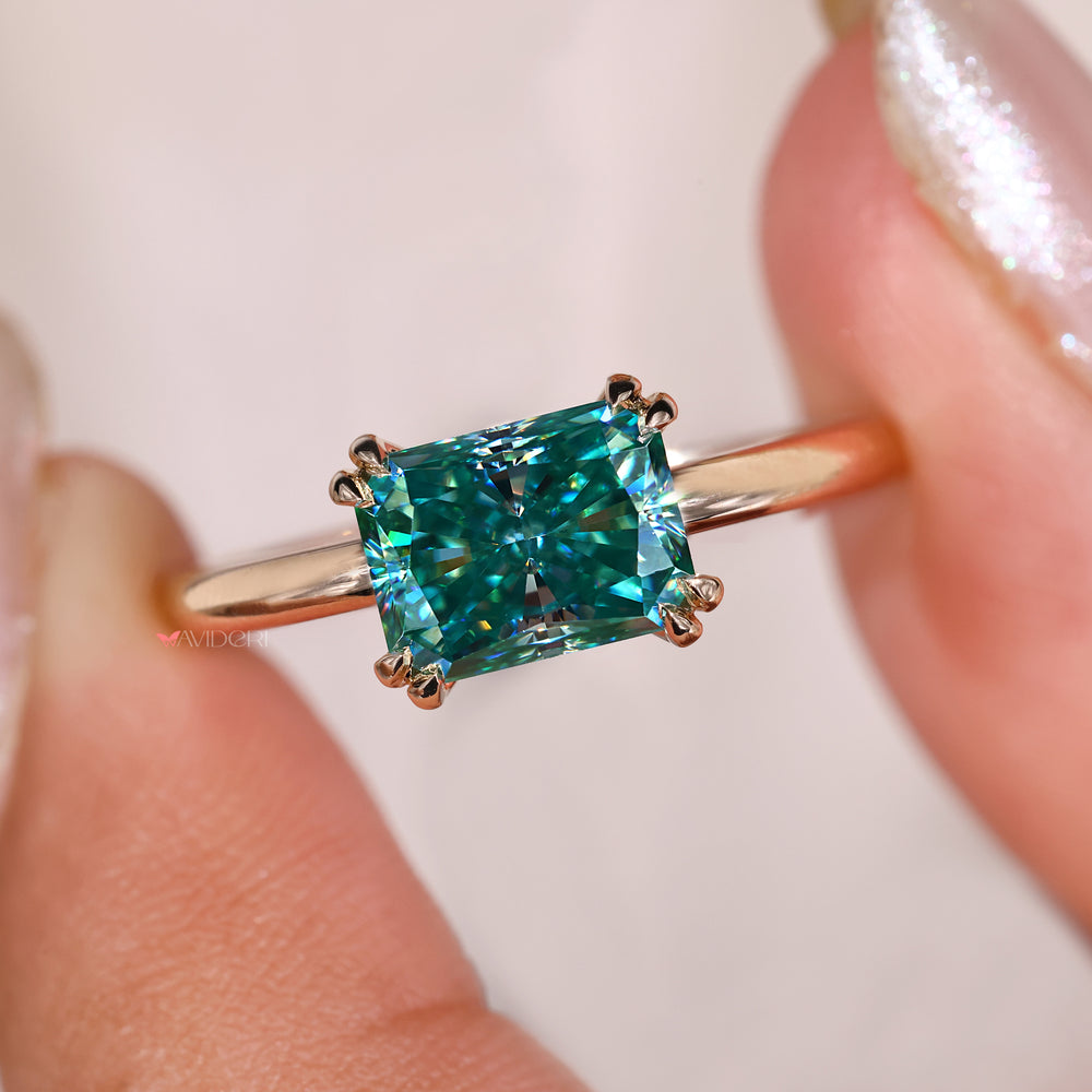 Cyan blue radiant cut ring designed in yellow gold.