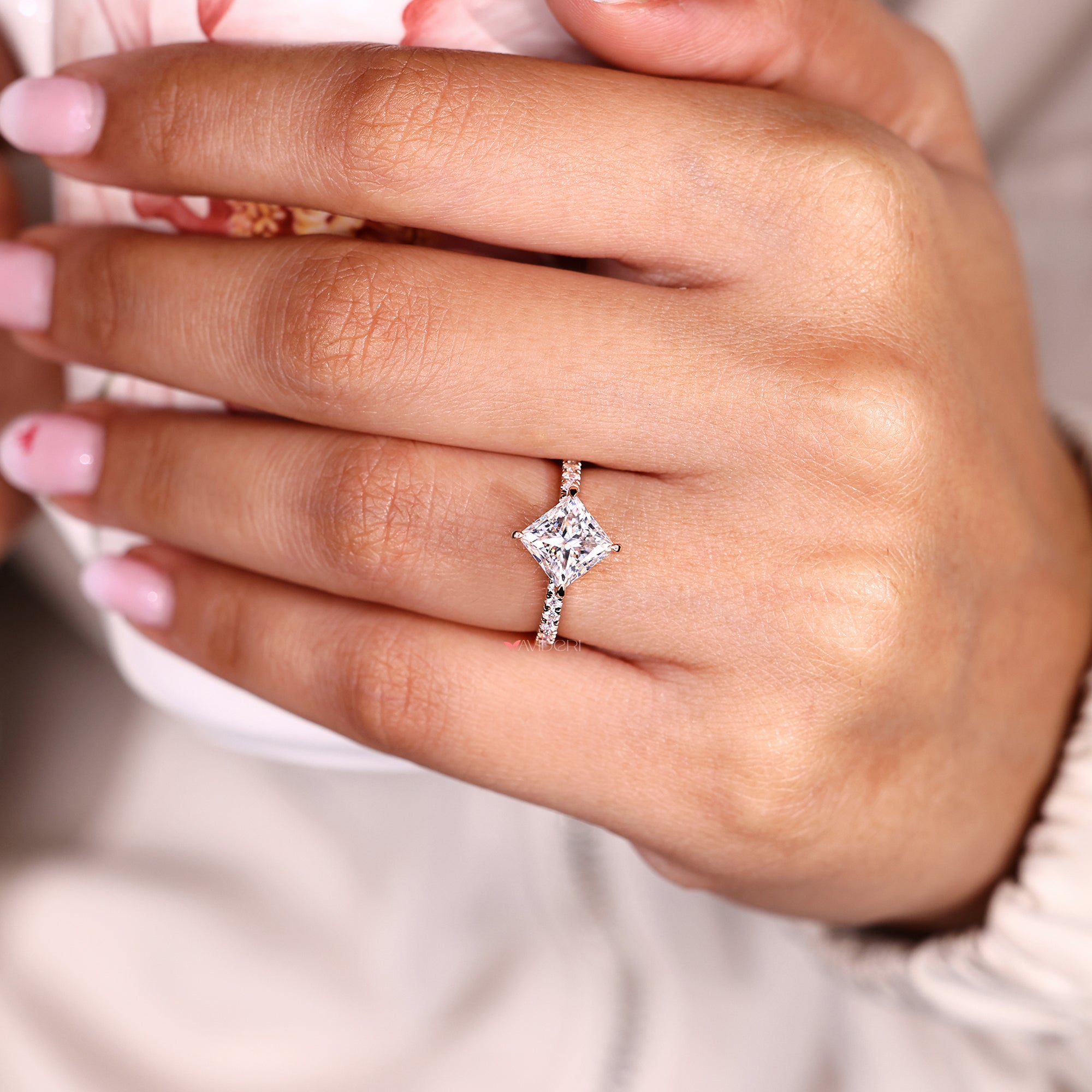 moissanite ring featuring compass prongs and pave-set side stones.