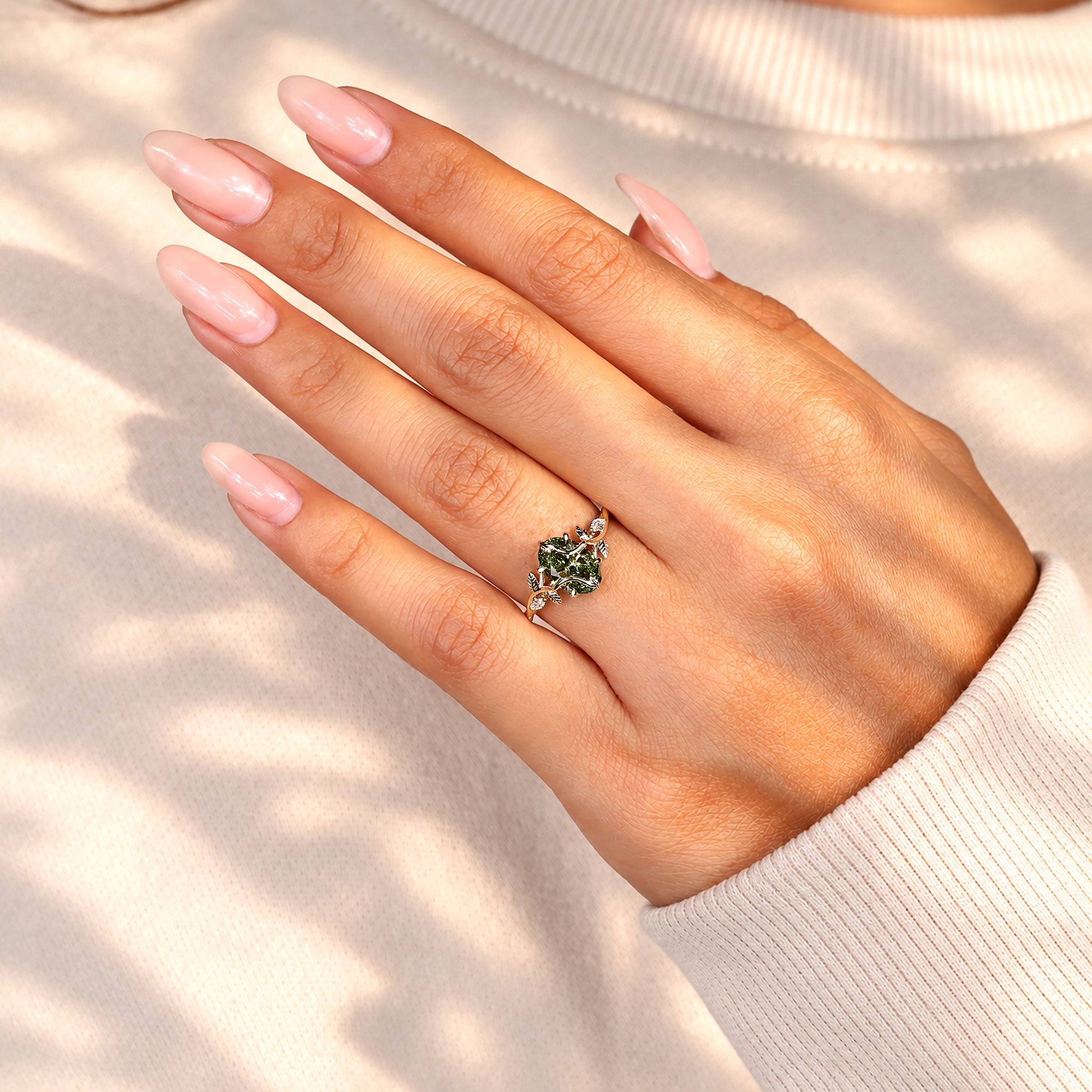 Lab grown oval green diamond ring with leaf prongs.