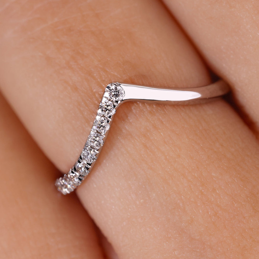 Round curved wedding band featuring round diamonds in white gold.